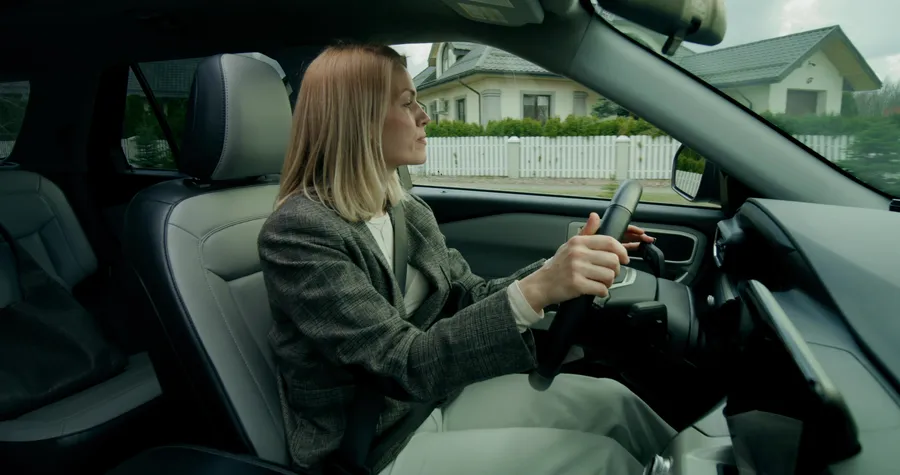 Nainen ajaa autoa kotoa työpaikalle.